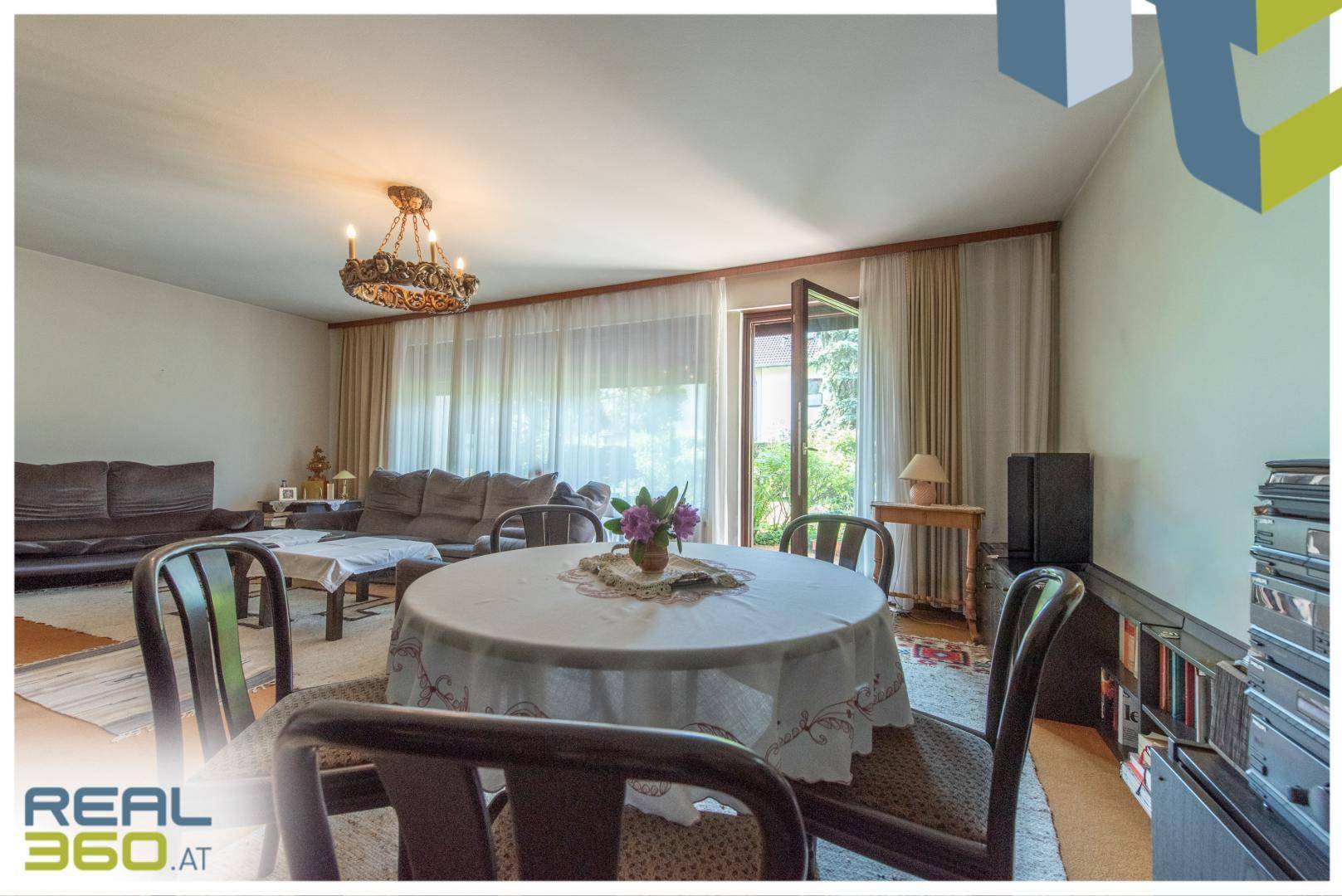 Geräumiger Wohn- und Essbereich mit großem Esstisch und direktem Zugang zur Terrasse.
