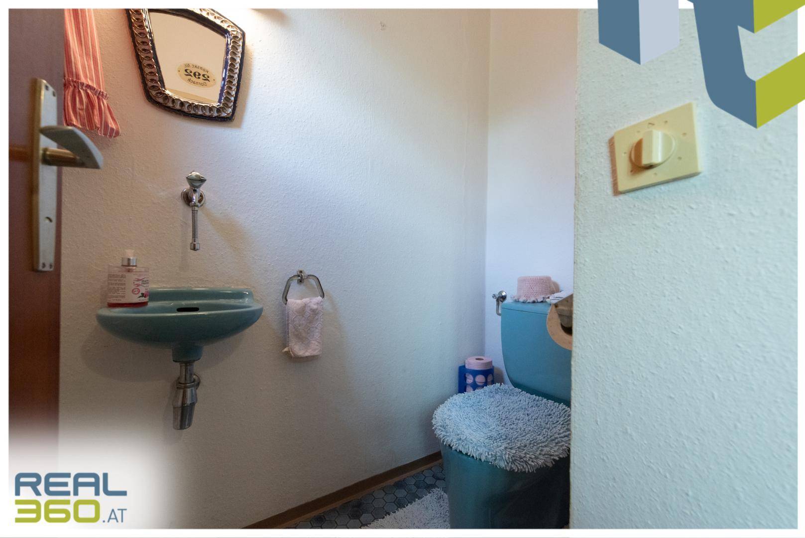 Kleines Gäste-WC mit hellblauer Keramik und schlichten Armaturen, typisch für die 80er Jahre.