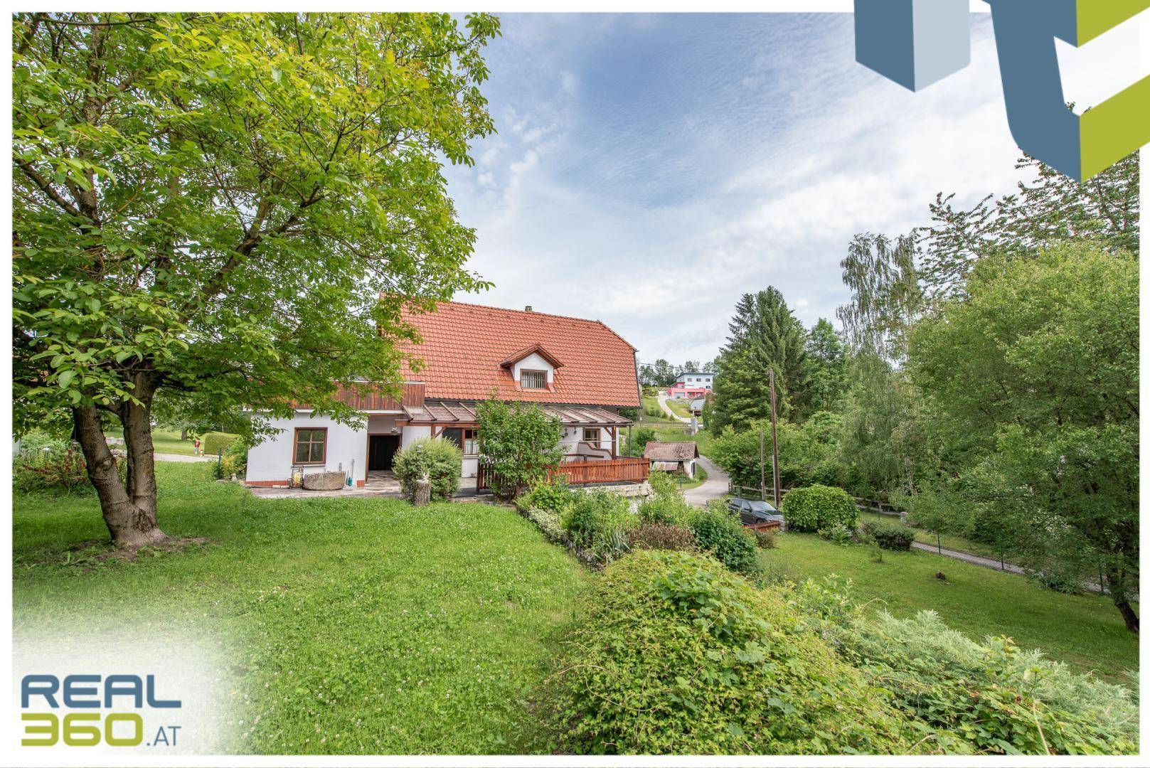 Weitläufiger Garten mit Rasenfläche und Blick auf das Wohnhaus mit Terrasse und Balkon.