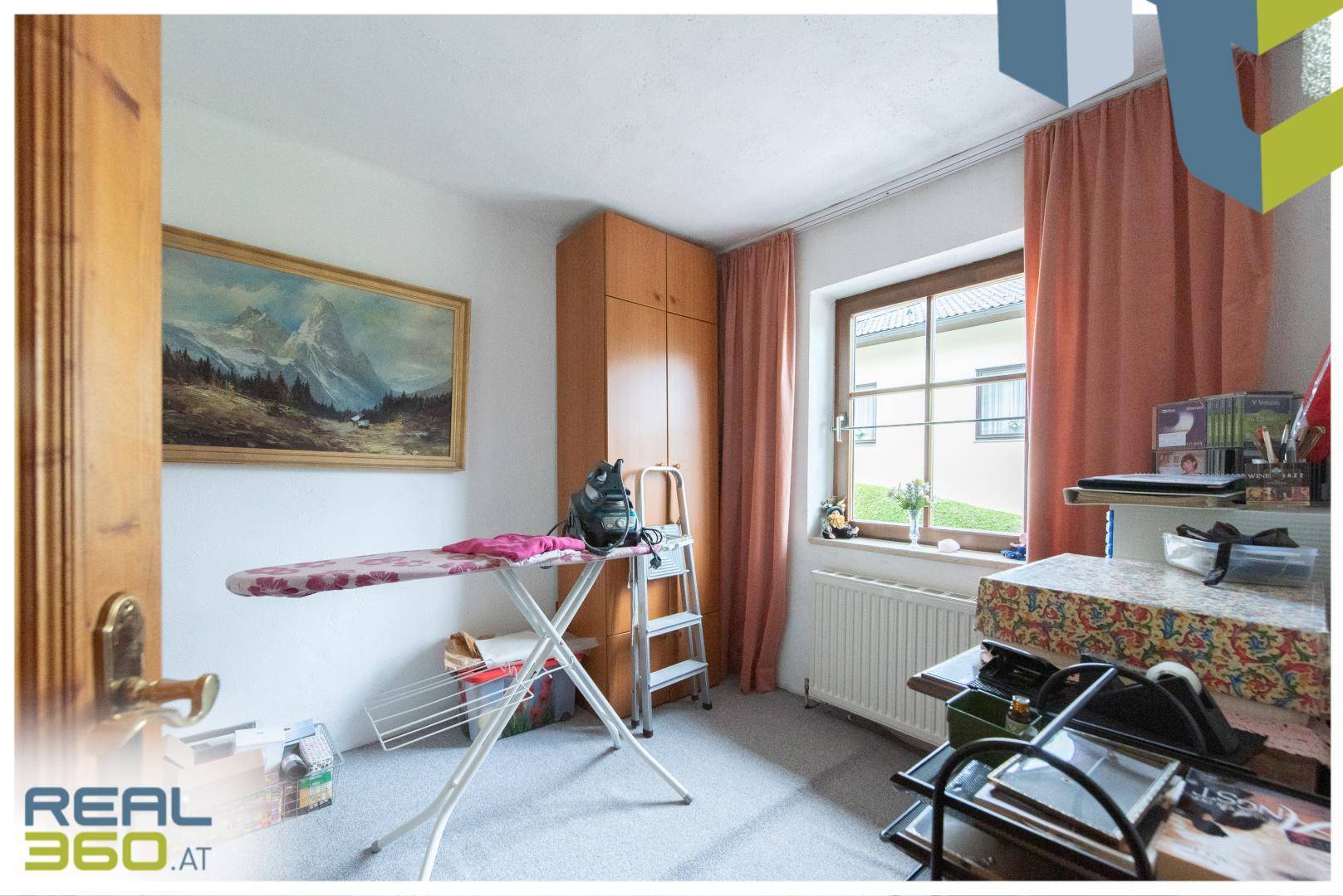 Praktischer Raum mit Bügelbrett, Schrank und Fenster, ideal als Hauswirtschaftsraum nutzbar.