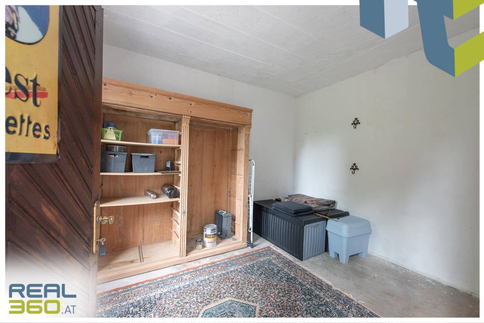 Praktischer Abstellraum mit Holzschrank, Teppich und viel Stauraum für diverse Gegenstände.