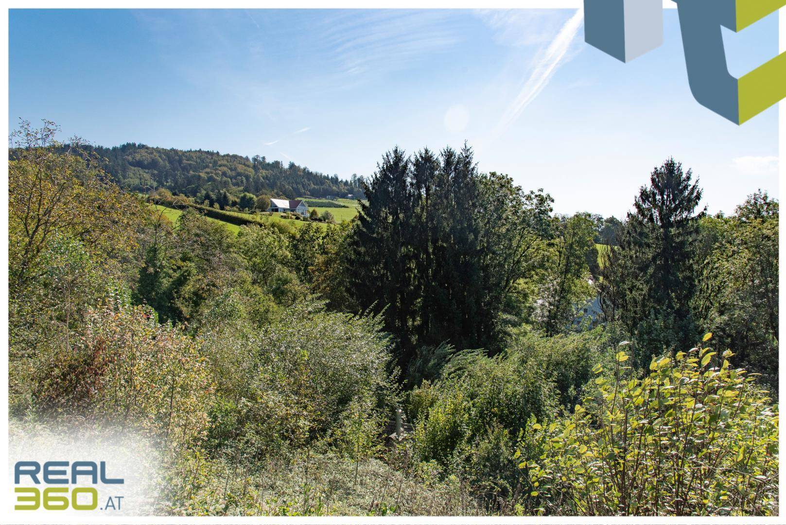 Malerische Hügellandschaft mit üppiger Vegetation und einem Haus in der Ferne unter blauem Himmel.