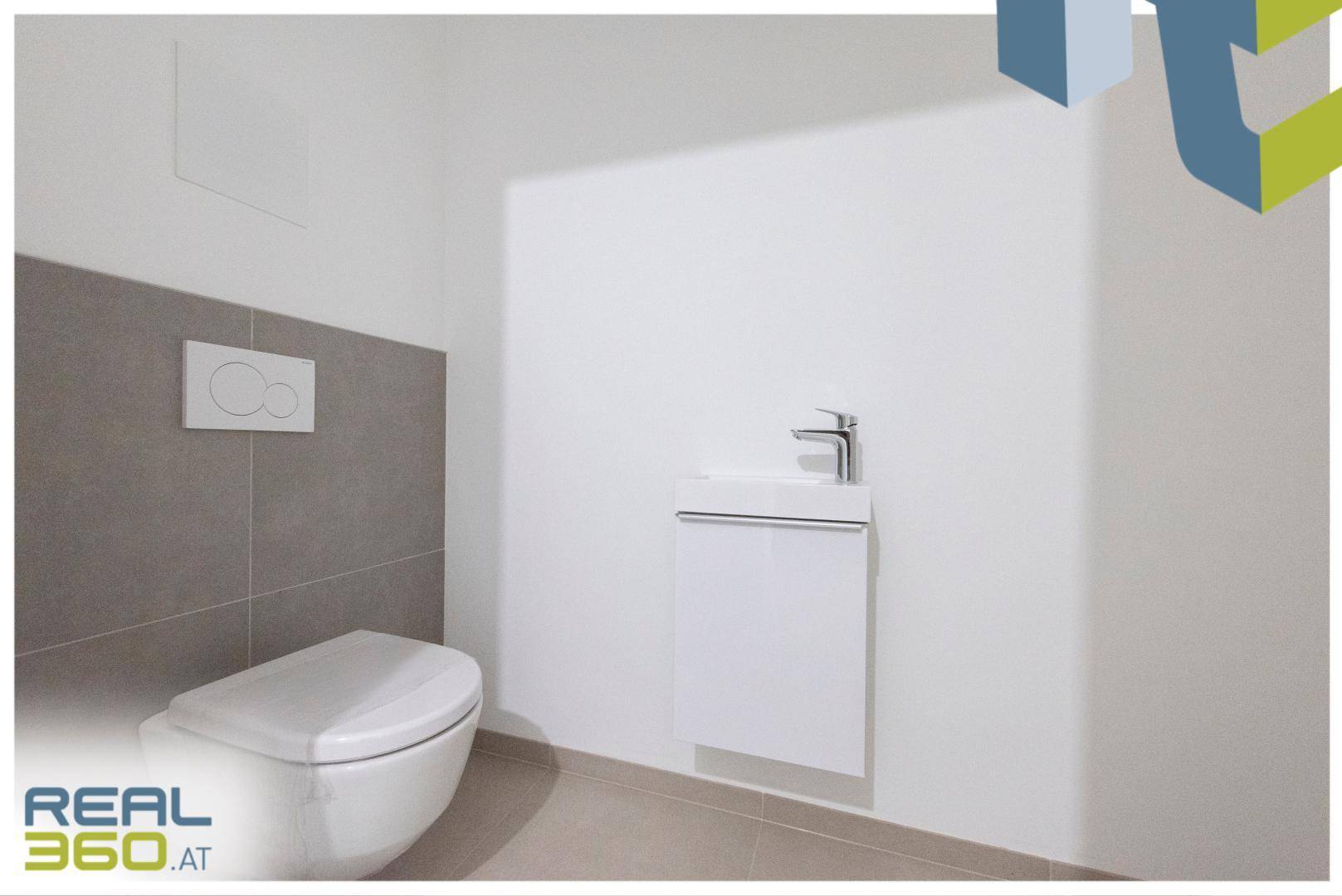 Modernes Gäste-WC mit wandhängender Toilette und kleinem Waschbecken.