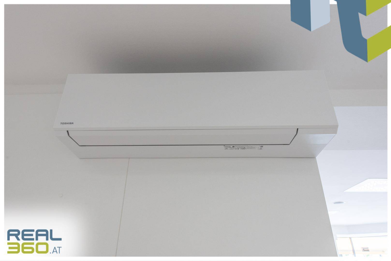 Nahaufnahme einer modernen Klimaanlage an der Wand eines hellen Geschäftsraums.