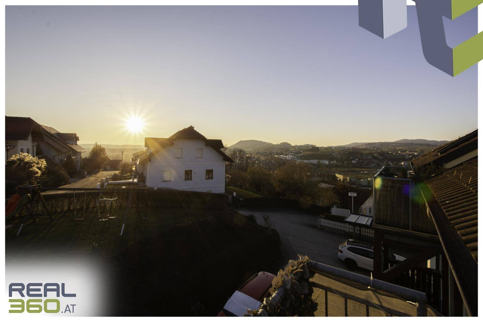 Malerischer Sonnenuntergang über der ländlichen Umgebung mit Häusern.