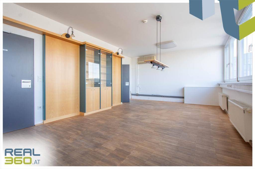 Büroraum mit Holzboden, Einbauschränken und Klimaanlage, bietet eine funktionale Arbeitsumgebung.