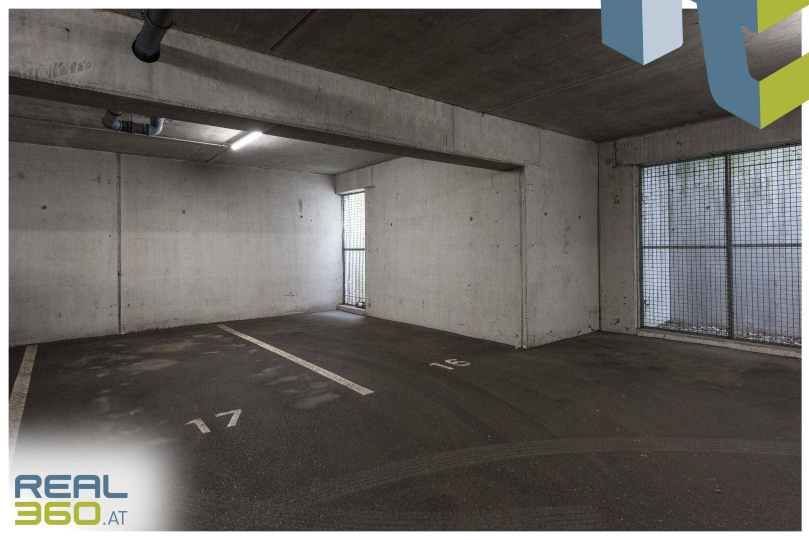 Geräumiger Tiefgaragenstellplatz mit Betonwänden und nummerierten Parkflächen.