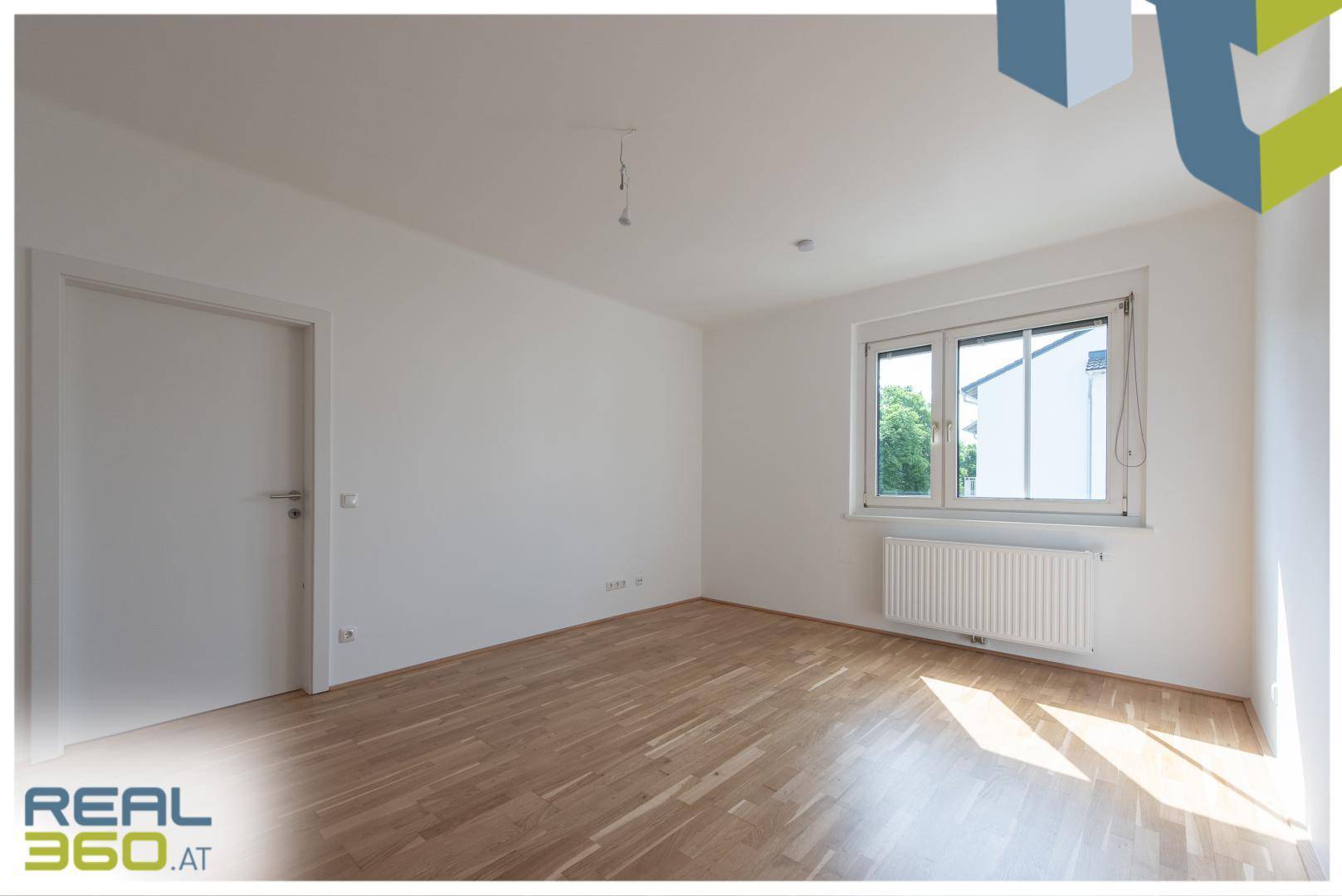 Freundliches Zimmer mit Parkettboden und weißen Wänden, ideal als Schlaf- oder Arbeitszimmer nutzbar.