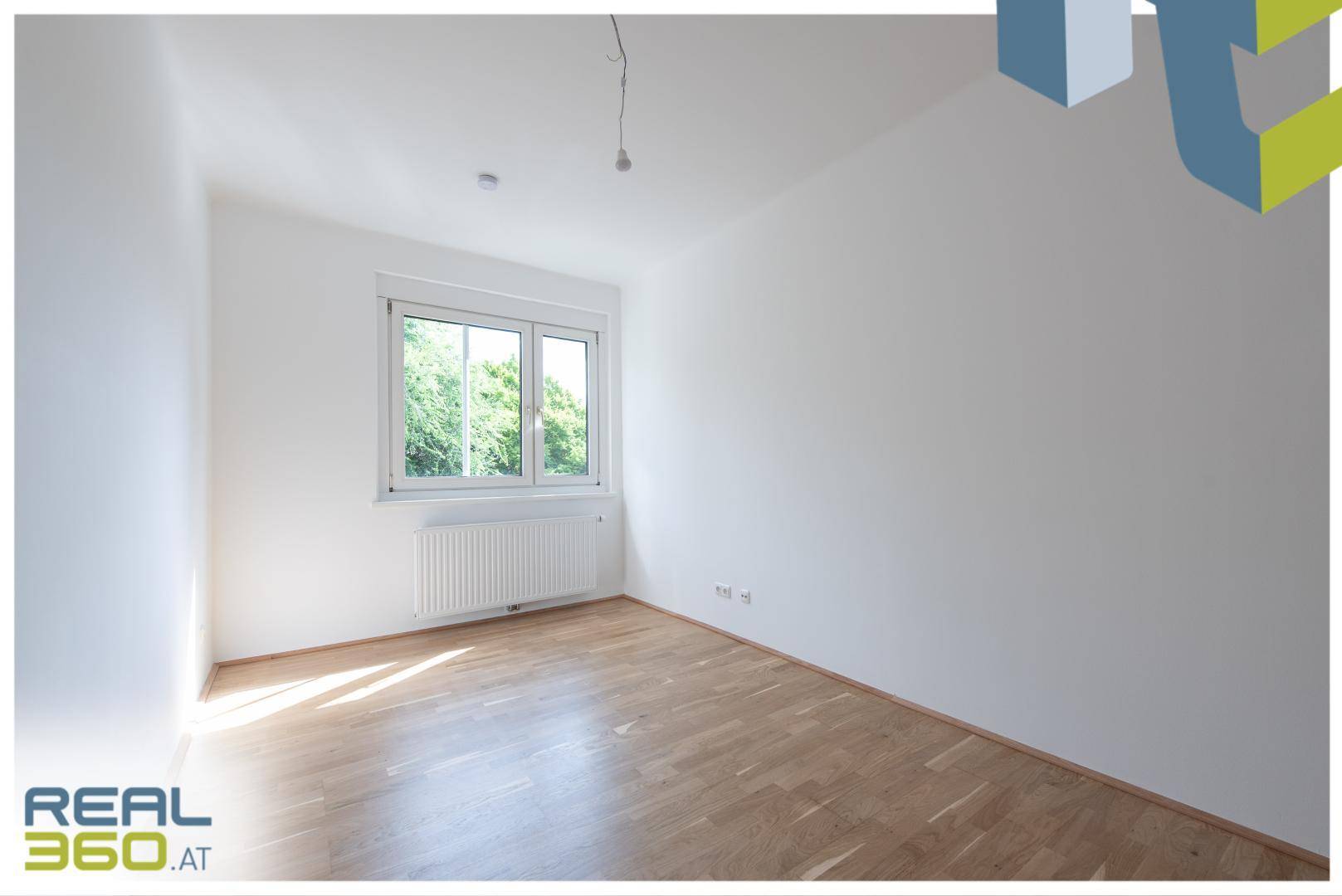 Helles Schlafzimmer mit Parkettboden, weißen Wänden und viel natürlichem Lichteinfall durch das Fenster.