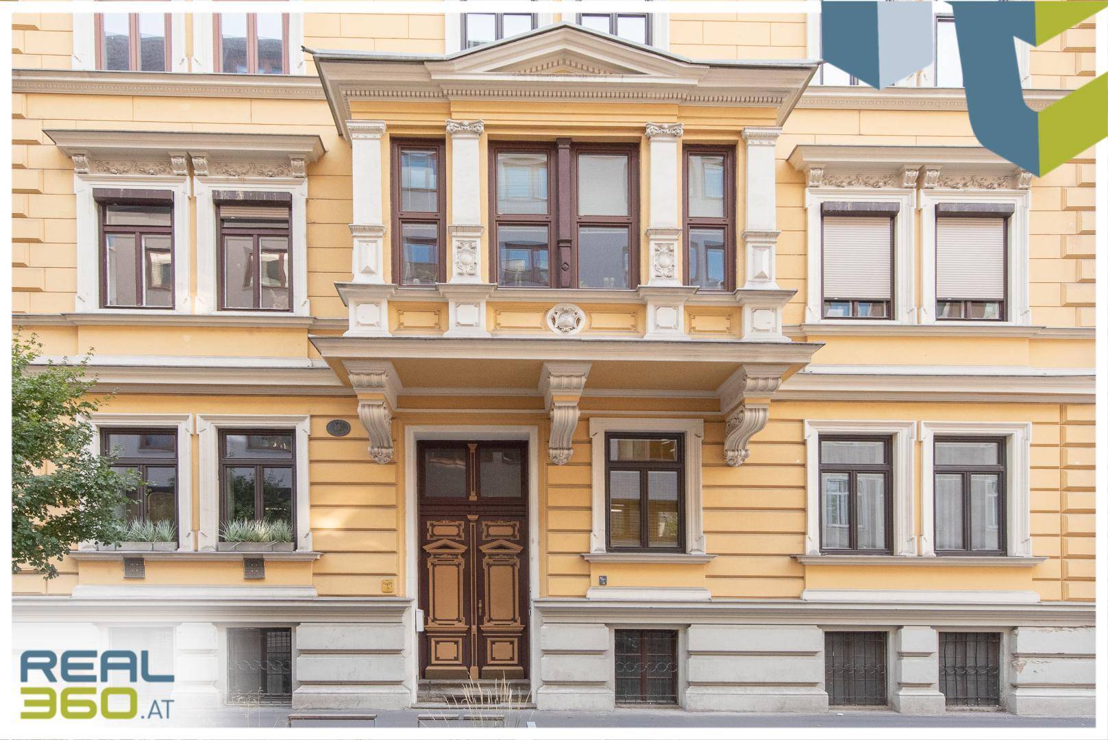 Historische Fassade eines eleganten Wohnhauses mit dekorativen Elementen und Holztür.