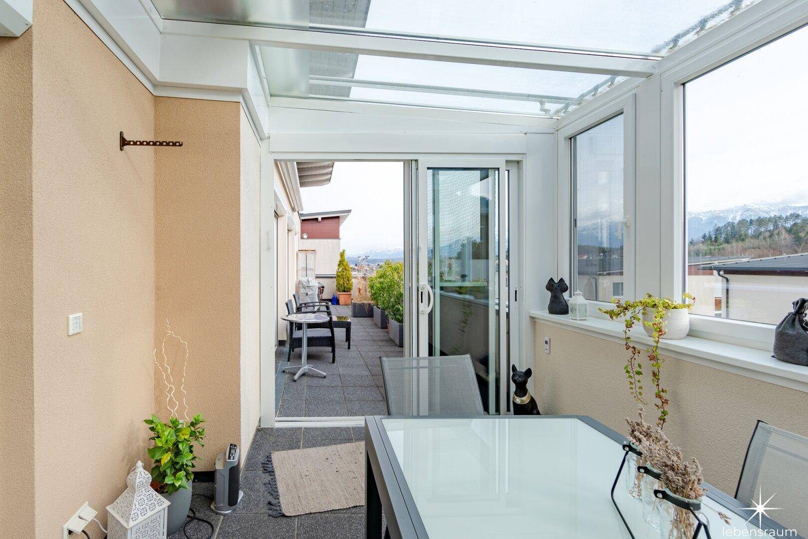 Gemütlicher Wintergarten mit Essbereich und direktem Zugang zur sonnigen Außenterrasse.