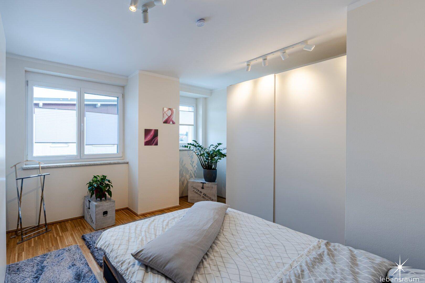 Helles Schlafzimmer mit Parkettboden und Einbauschränken, bietet eine ruhige Atmosphäre.