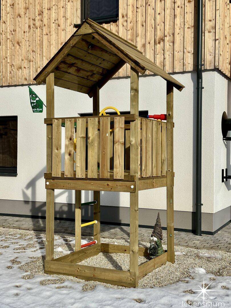 Hölzernes Spielgerüst im Gartenbereich für Kinder zum Klettern und Spielen.