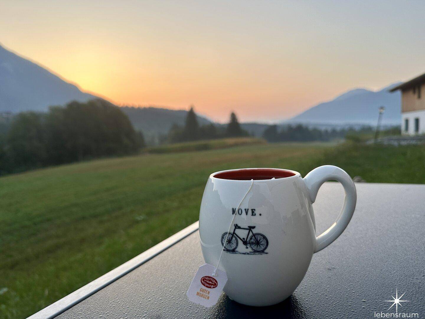 Morgenkaffee mit malerischem Blick auf die Berge und grüne Landschaft bei Sonnenaufgang.