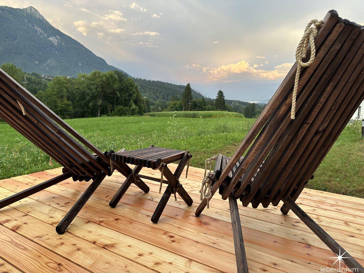 Gemütliche Holzliegen auf der Terrasse mit weitem Blick auf die Berge und Natur.