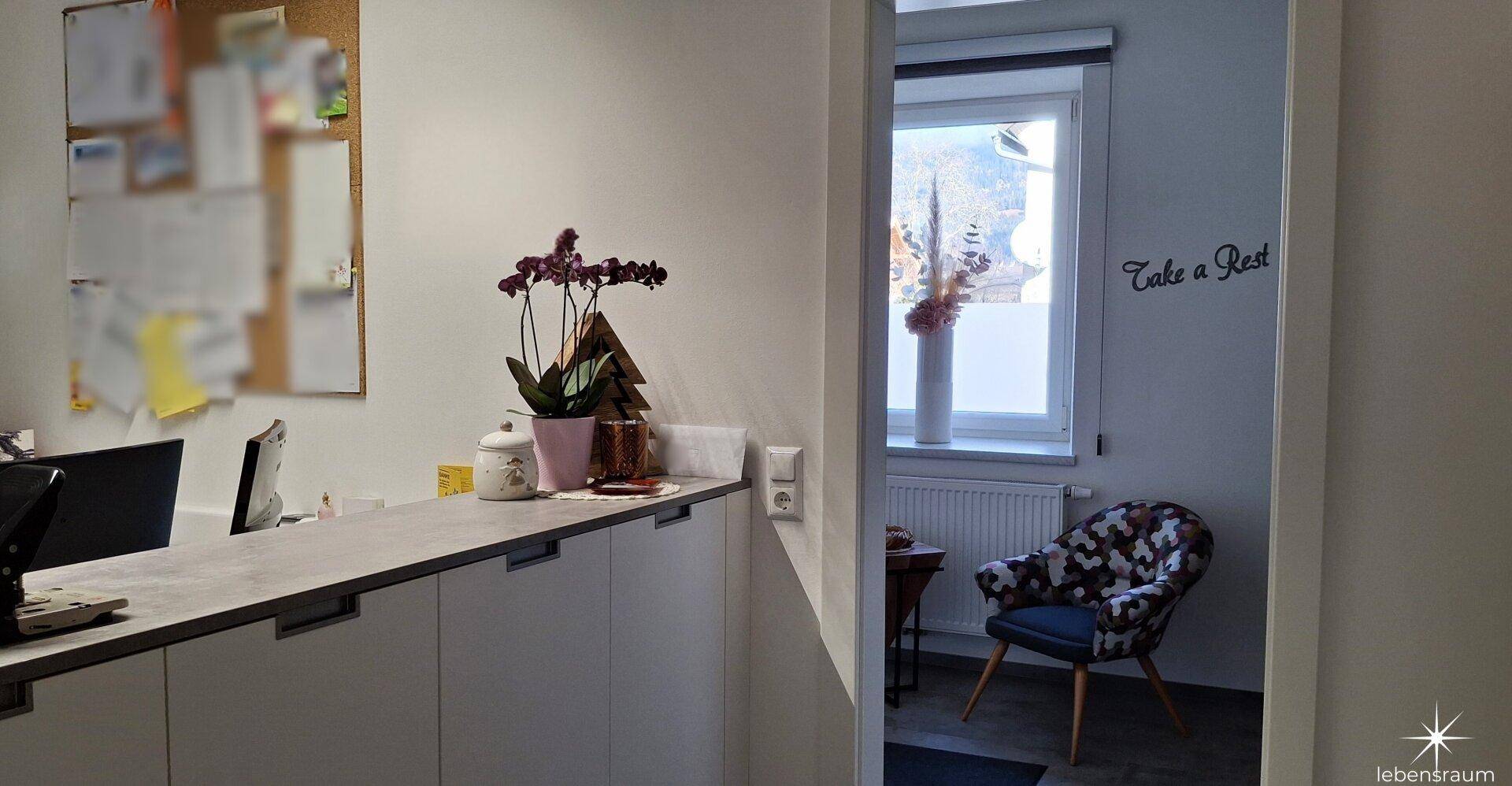 Empfangsbereich oder Büro mit einer Theke und Blick in einen gemütlichen Loungebereich.