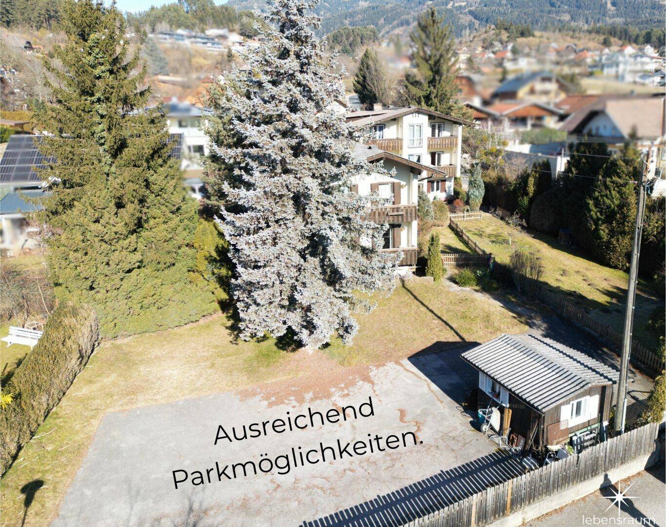 Luftaufnahme des Grundstücks mit ausreichend Parkmöglichkeiten und Nebengebäude.
