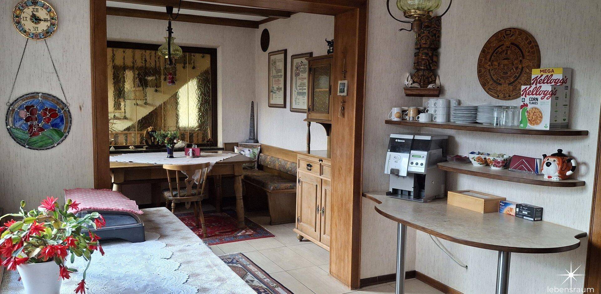 Gemütlicher Essbereich mit traditionellen Holzmöbeln und Kaffeemaschine.