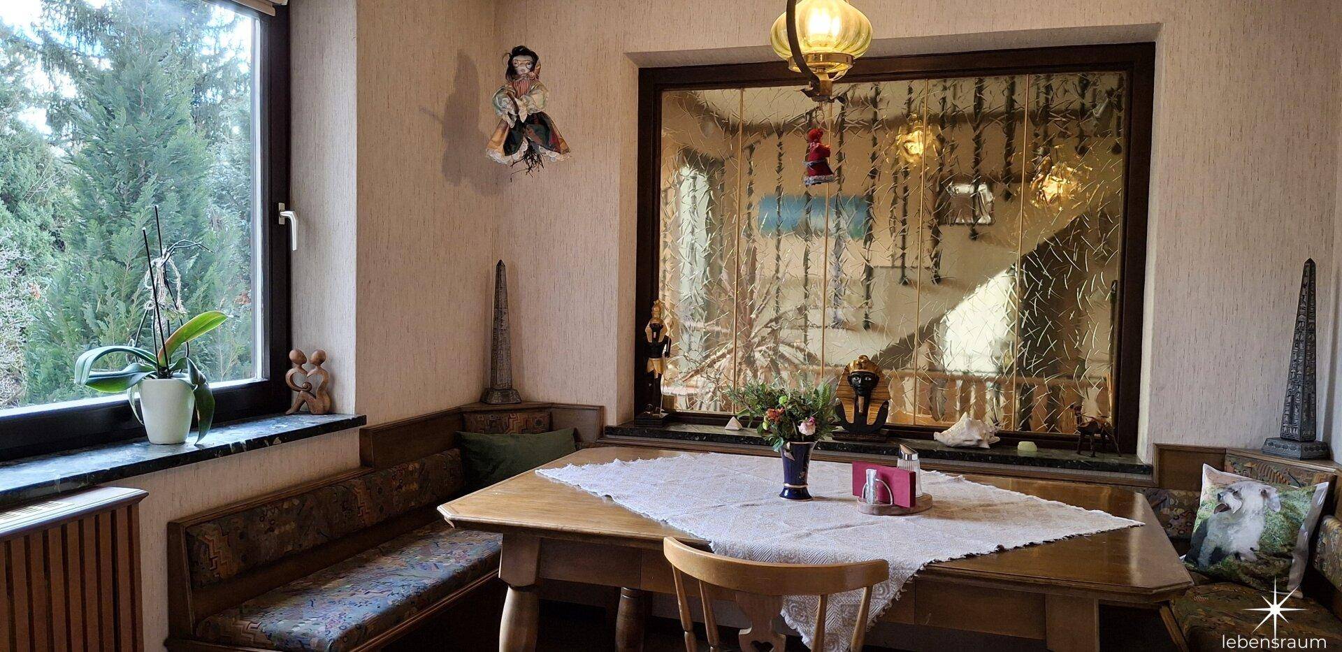 Heller Essbereich mit Holztisch, Eckbank und Blick ins Grüne.