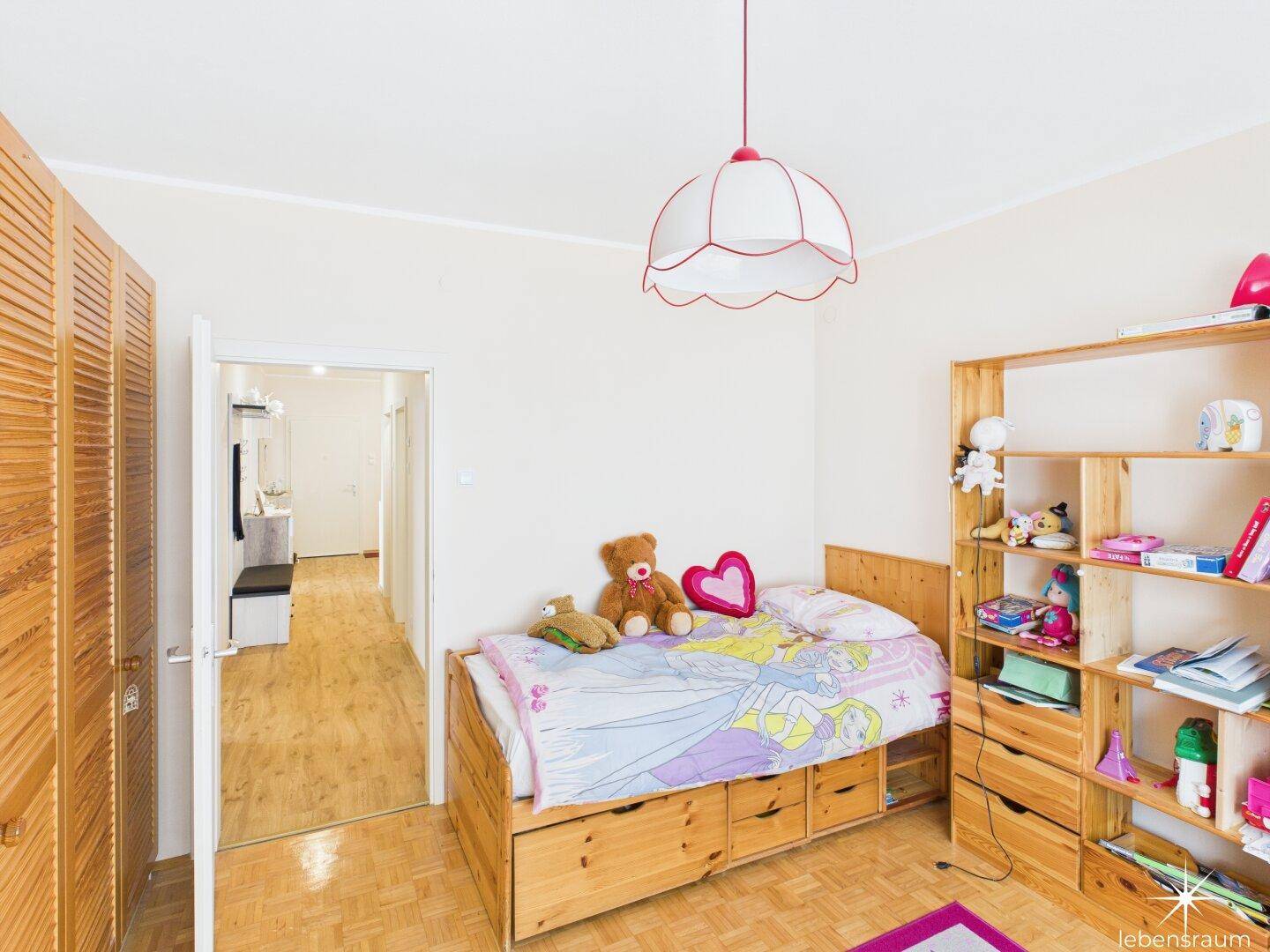Kinderzimmer mit Einzelbett, Holzregal und Kleiderschrank, ideal für ein Kind.
