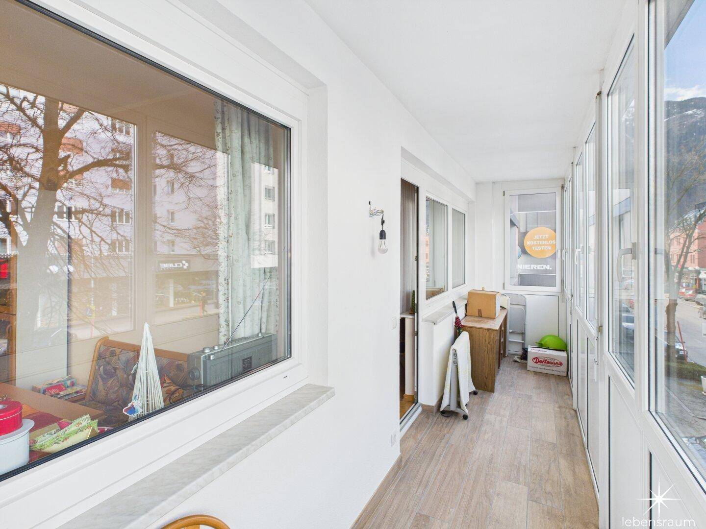 Verglaste Loggia mit Blick auf die Umgebung, genutzt als erweiterter Wohnraum.