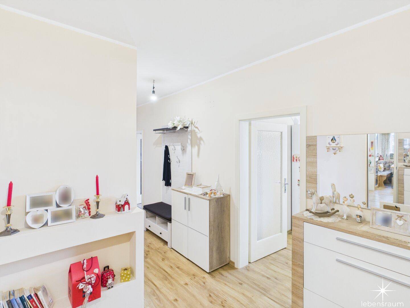 Flur mit Garderobe, Schuhschrank und hellem Laminatboden, der einladend wirkt.