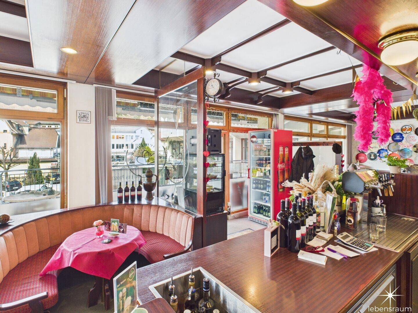 Barbereich mit Sitzgelegenheiten, Theke und Blick auf die Außenterrasse.