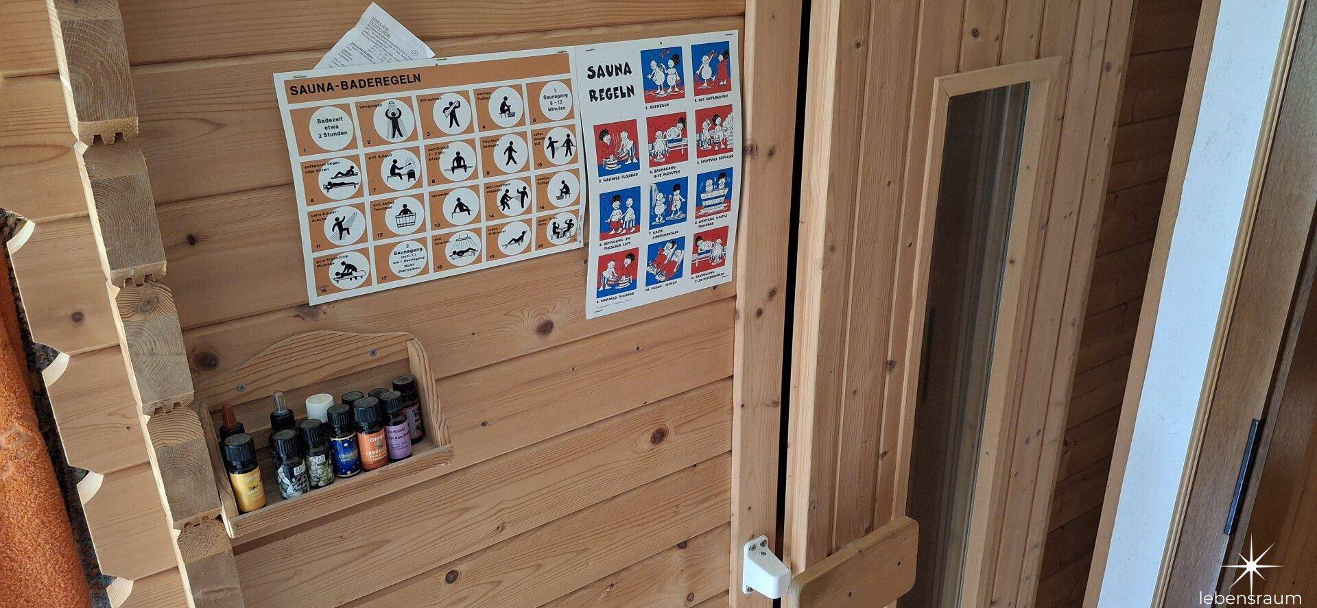 Holzkabine einer Sauna mit Sauna-Bade-Regeln an der Wand, bereit zur Nutzung.
