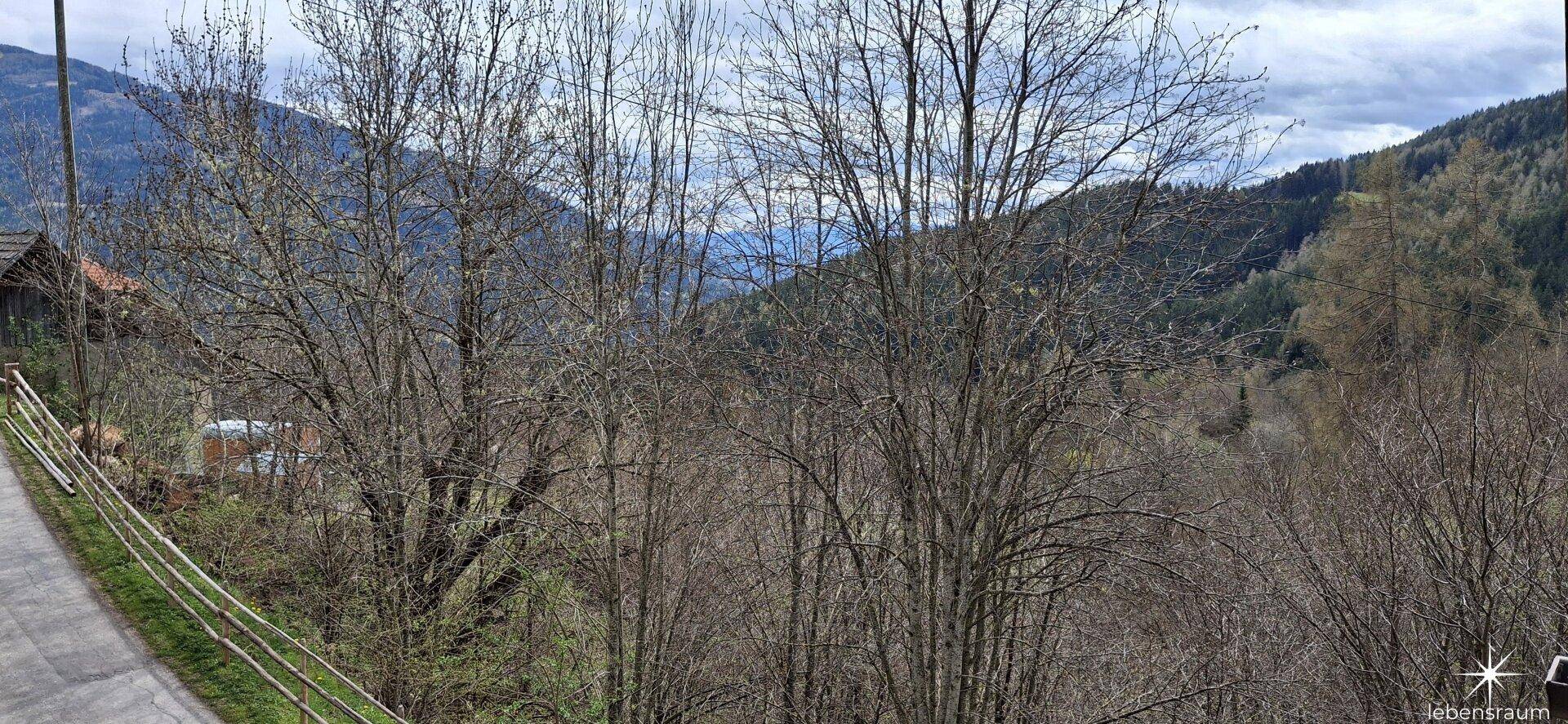Weitläufiger Blick auf die ländliche Umgebung und die bewaldeten Berge.