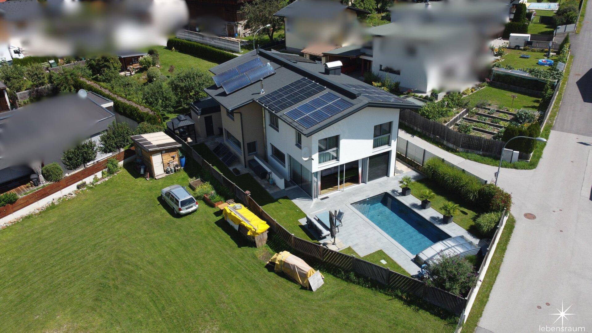 Luftaufnahme des Hauses mit Pool, Garten und Photovoltaikanlage auf dem Dach.