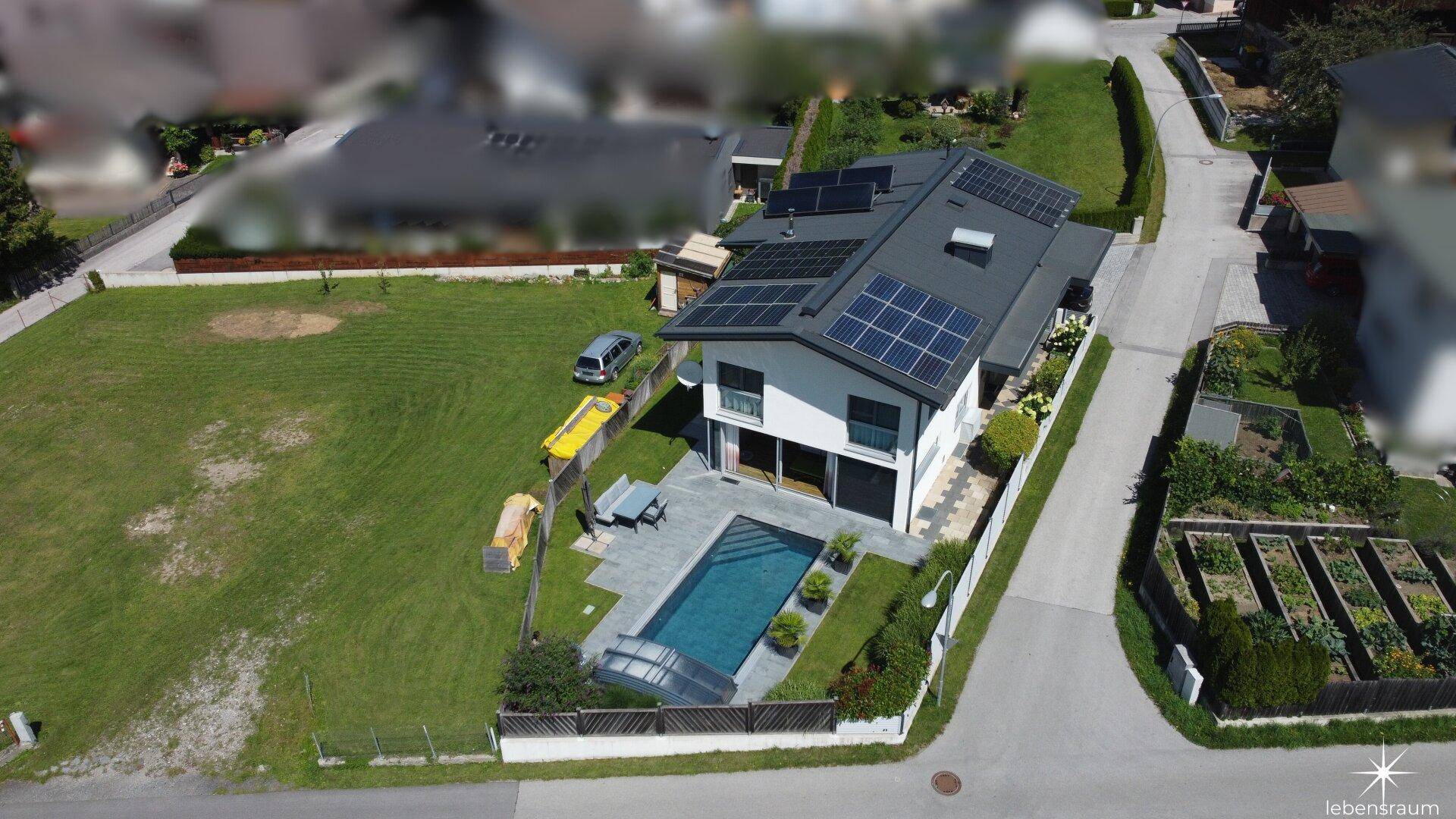 Übersicht aus der Vogelperspektive mit Haus, Pool, Garten und Solaranlage.