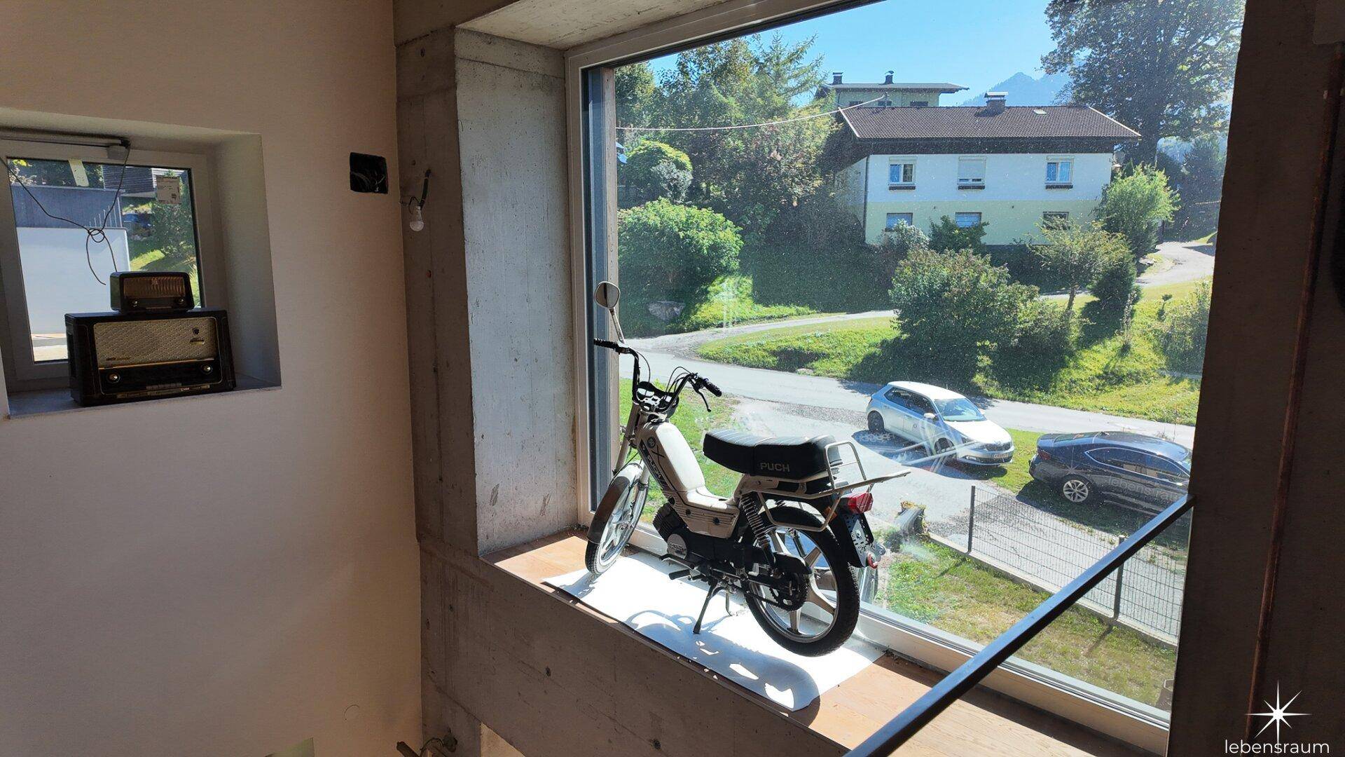 Große Fensterfront mit Blick auf die ländliche Umgebung und die Straße.