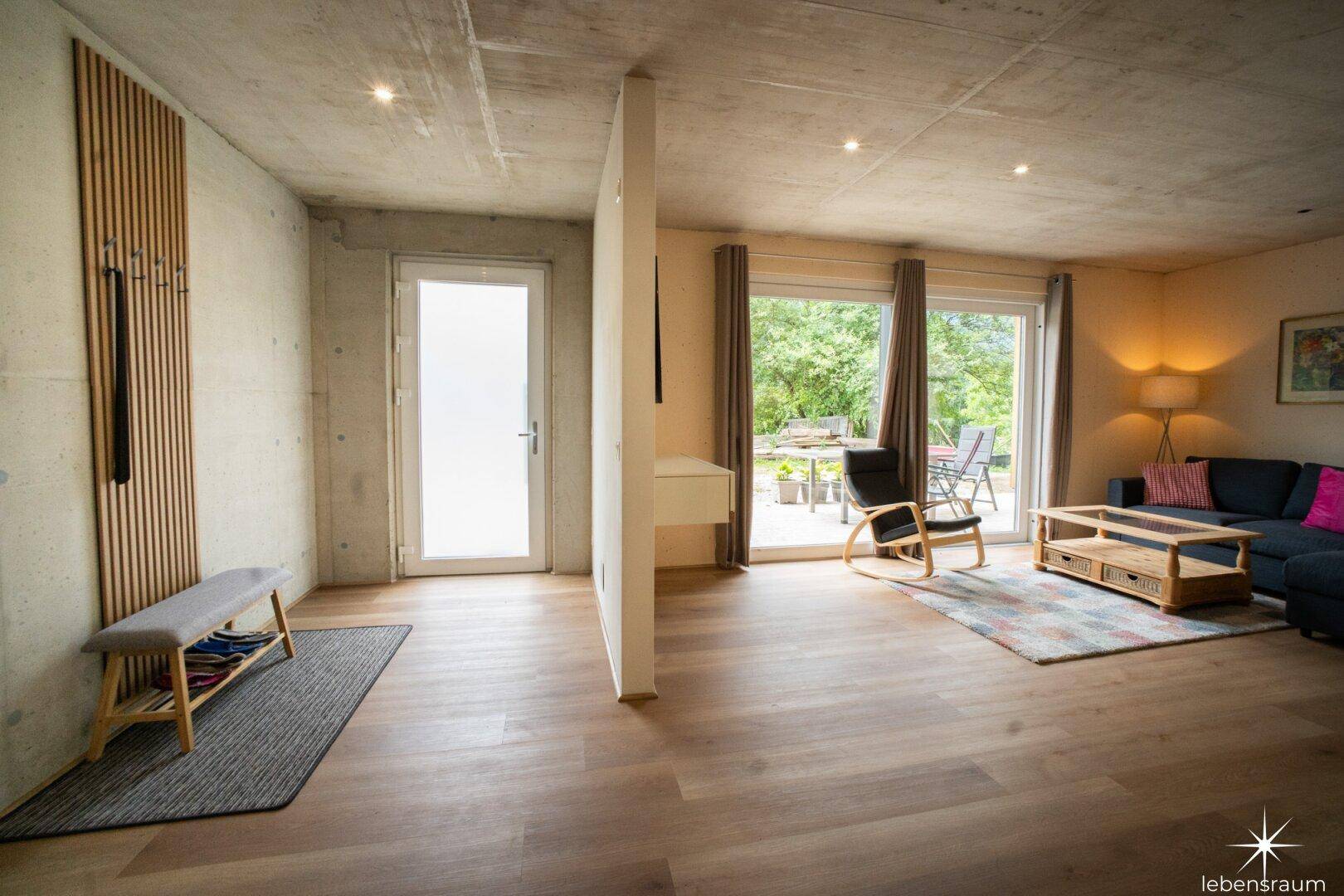 Eingangsbereich mit Holzboden, Garderobe und Zugang zu den Wohnräumen.