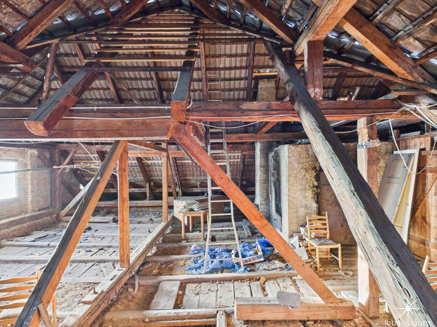 Großer Dachboden mit sichtbaren Holzbalken und Dachkonstruktion, bereit für den Ausbau und Umgestaltung.