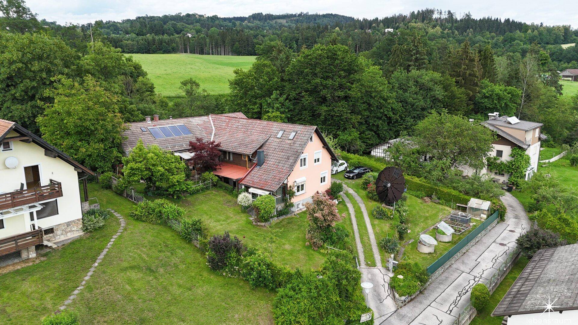 Weitläufige Luftaufnahme des Anwesens mit angrenzenden Feldern und Wäldern in ländlicher Umgebung.