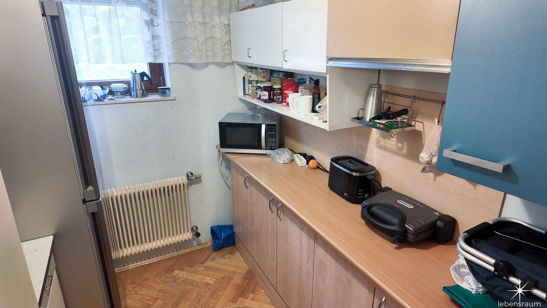 Funktionale Küchenzeile mit Mikrowelle, Toaster und ausreichend Arbeitsfläche.