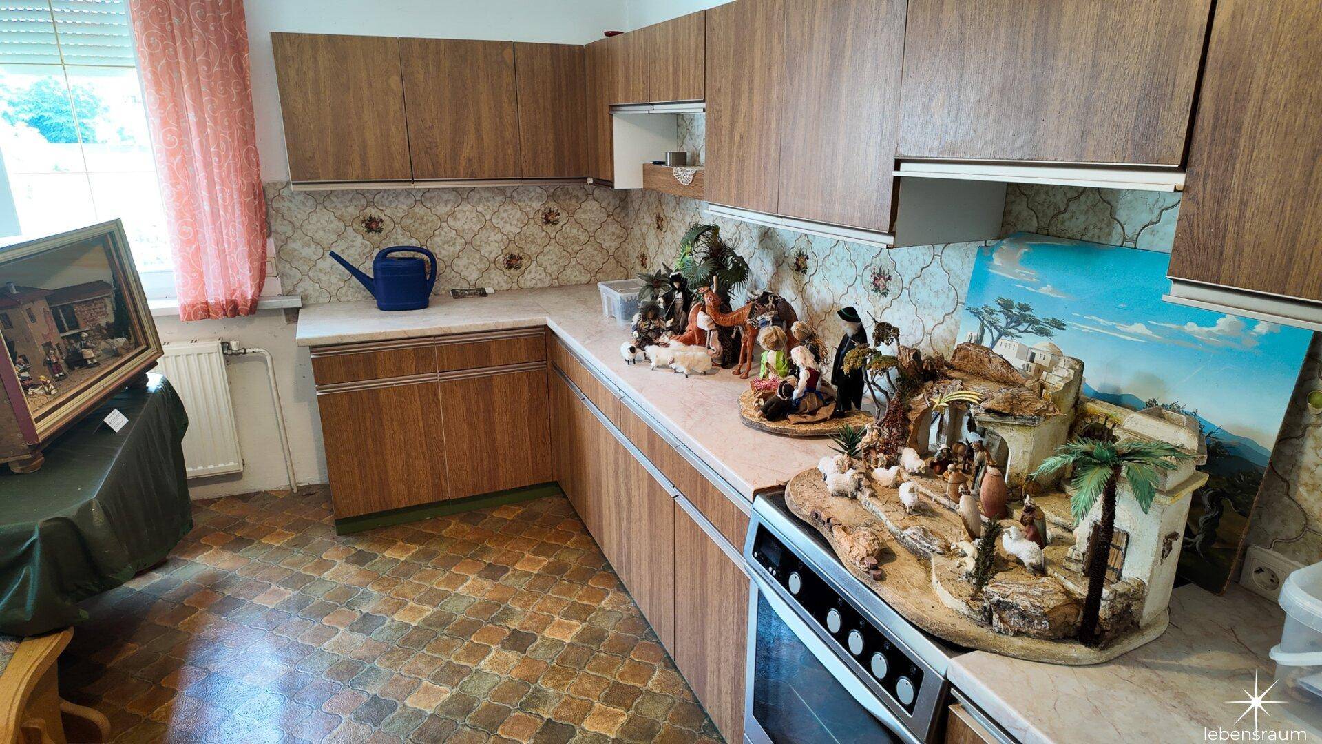 Geräumige Küche mit Holzschränken, gemusterten Fliesen und viel Stauraum.