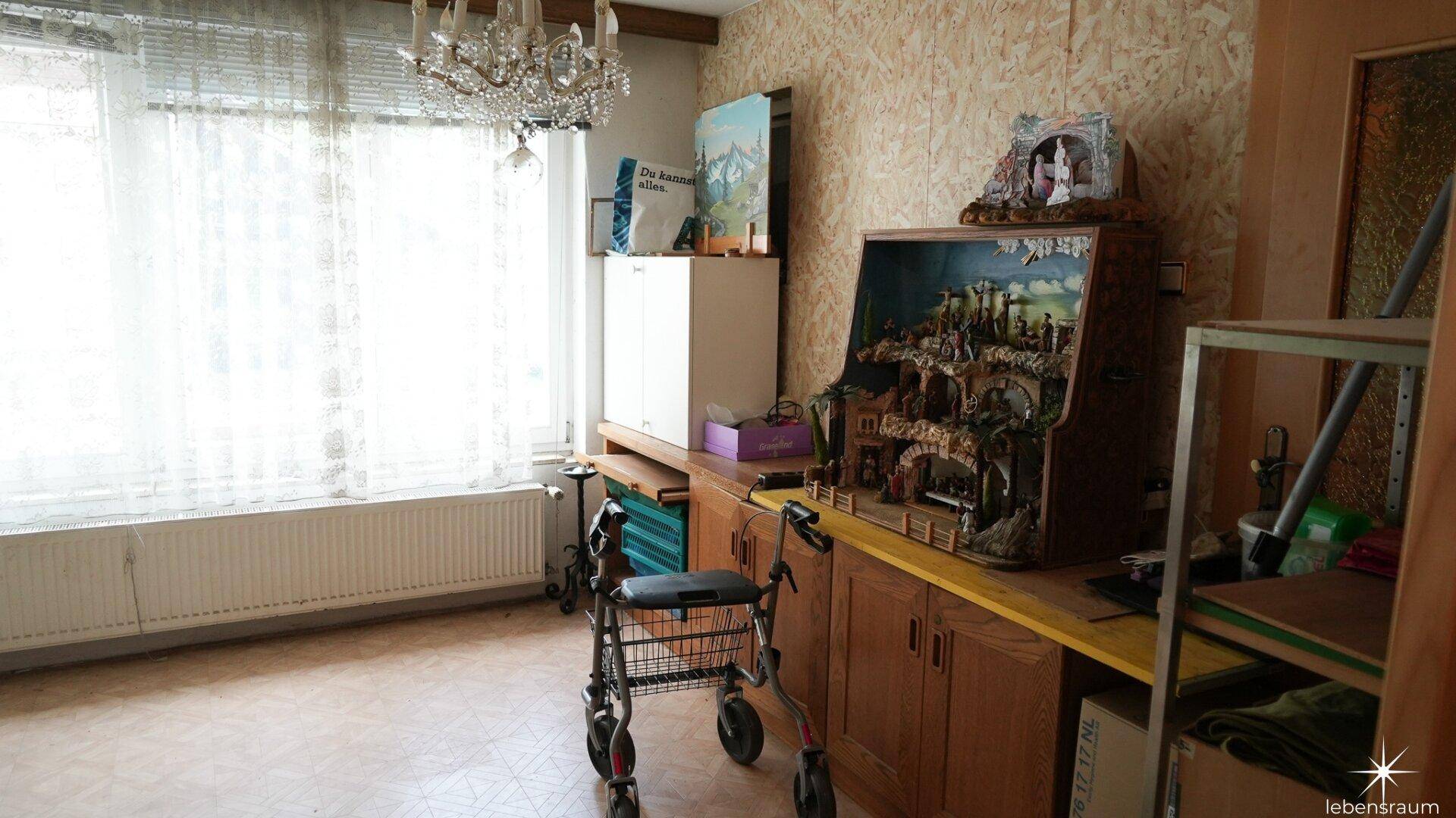 Abstellraum mit Regalen, Fenster und einem Rollator, der auf eine Nutzung als Hobbyraum hindeutet.