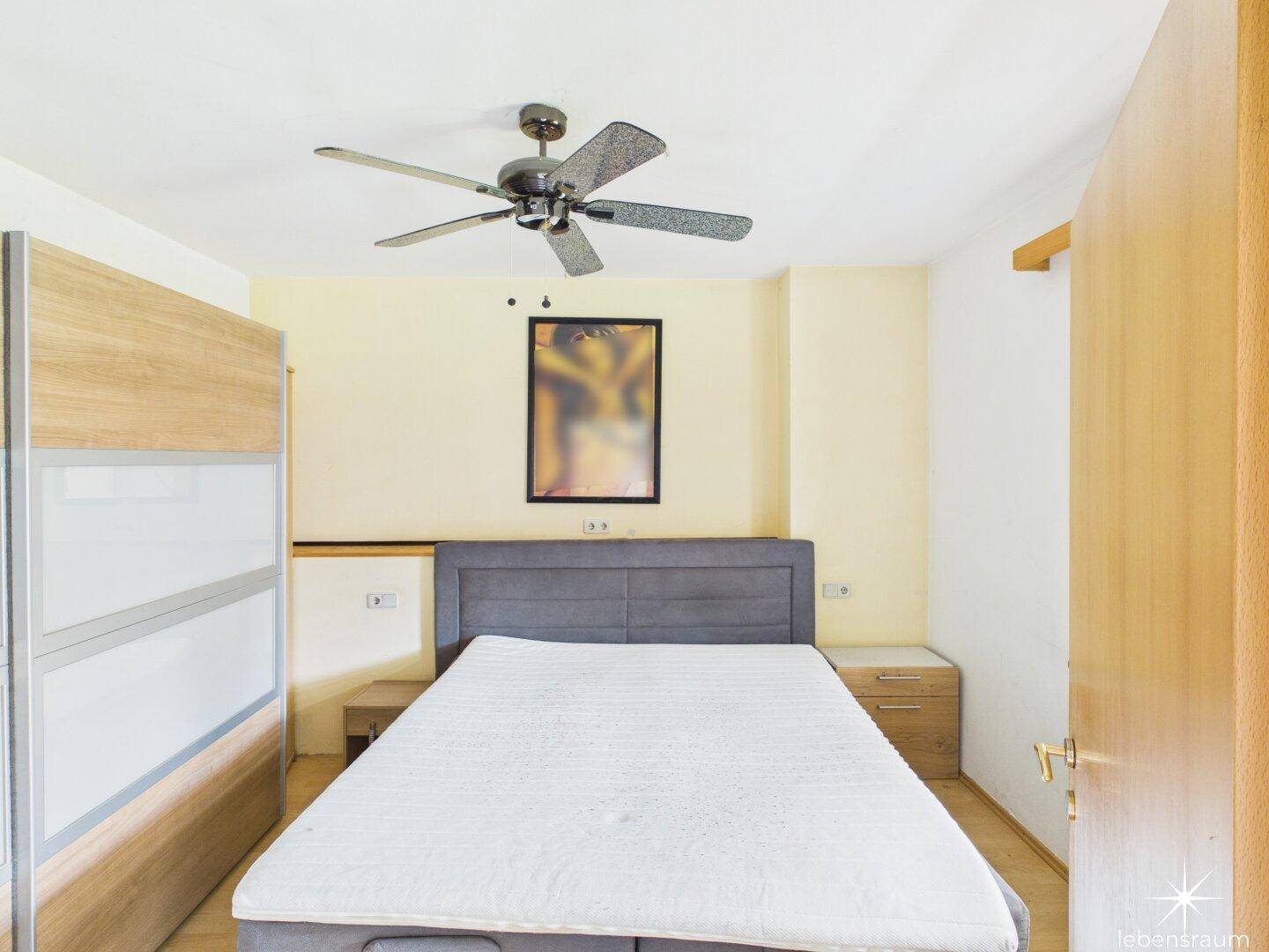 Modern eingerichtetes Schlafzimmer mit Doppelbett, Deckenventilator und hellem Ambiente.