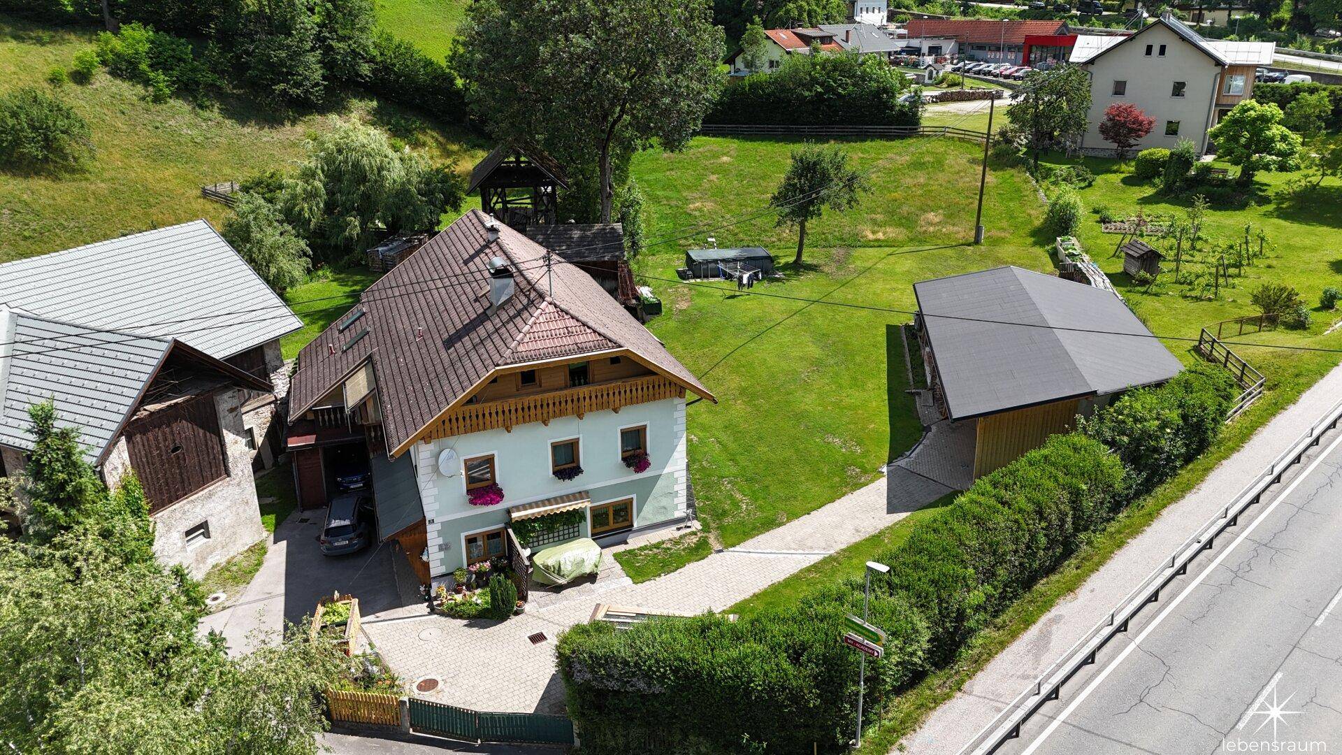 Weitläufige Luftaufnahme des Anwesens mit Haupthaus, Nebengebäude und großem Grundstück.