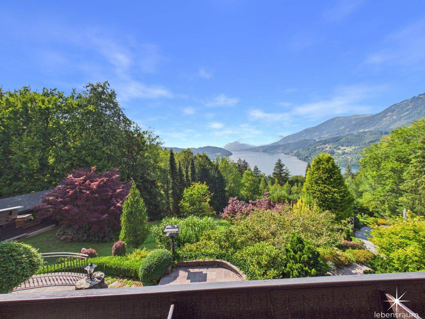 Atemberaubender Ausblick von einem Balkon auf den See, die Berge und die grüne Landschaft.