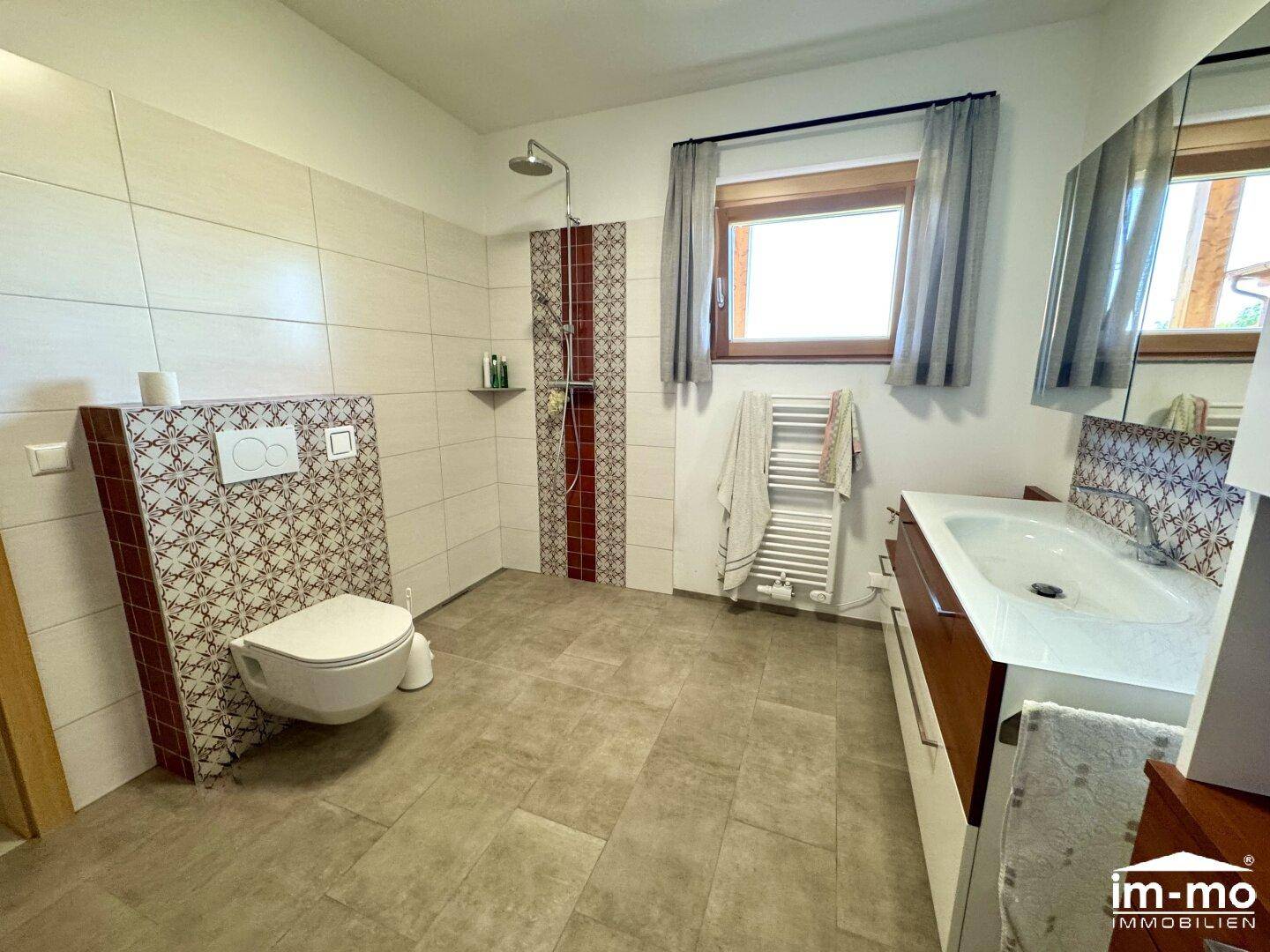 Modernes Badezimmer mit ebenerdiger Dusche, Wand-WC und Fenster.