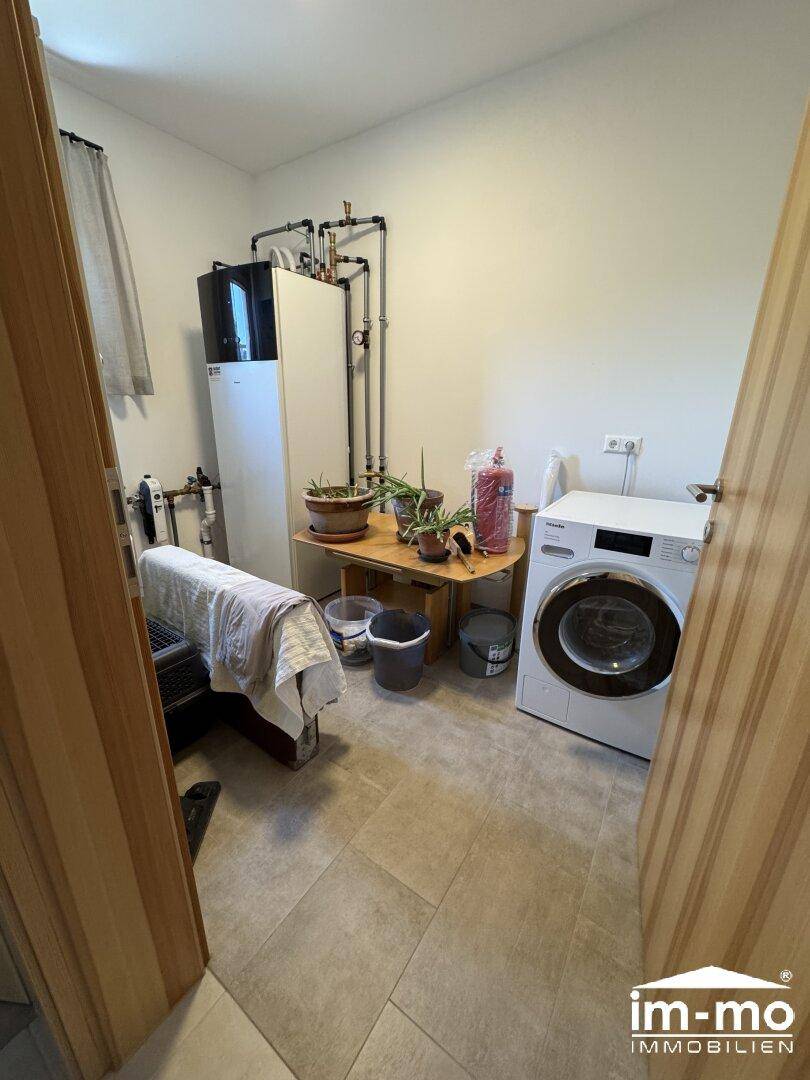 Hauswirtschaftsraum mit Waschmaschine und moderner Heizungsanlage.