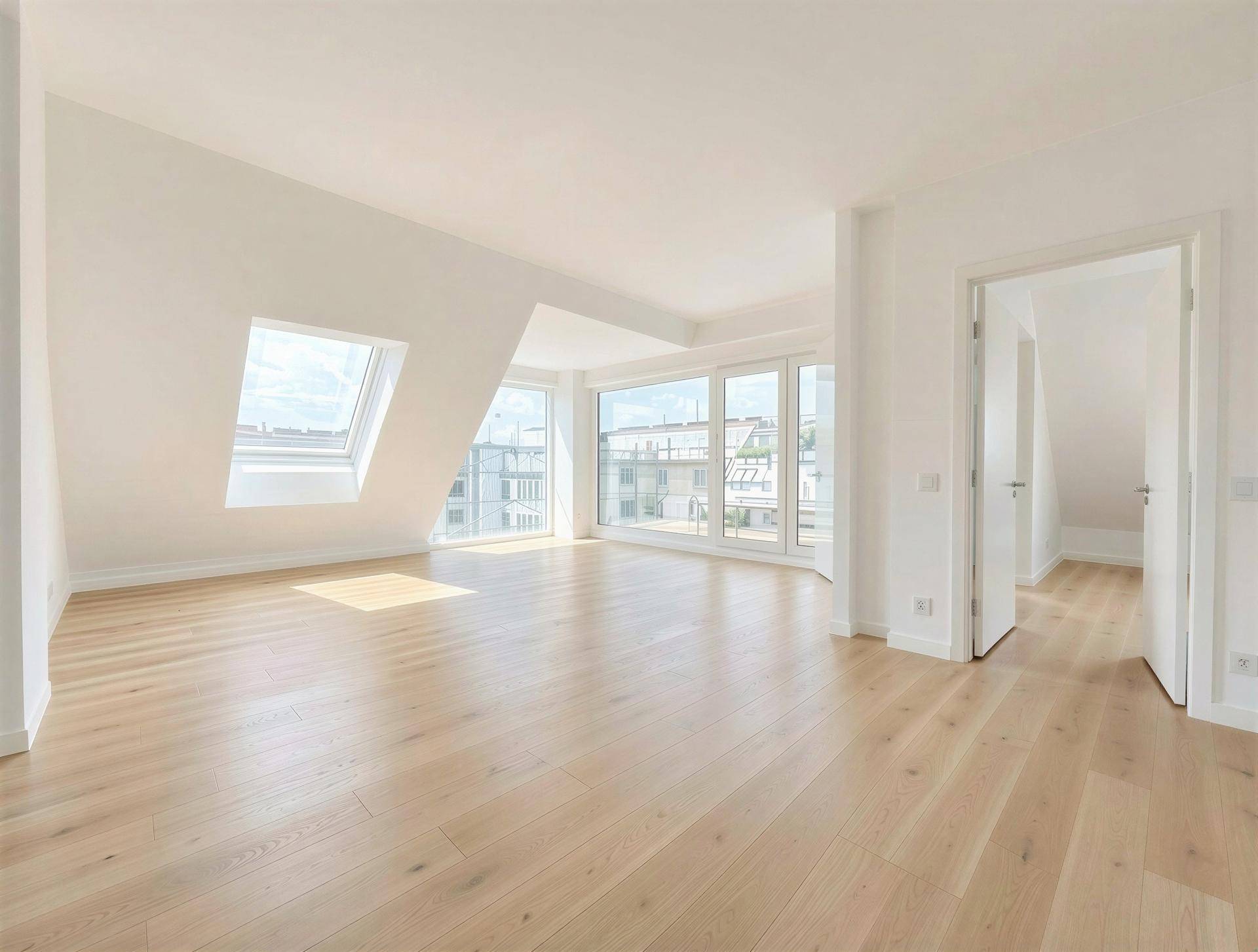 Heller Wohnraum mit Dachschrägen, großen Fenstern und neuem Holzboden, bietet viel natürliches Licht.