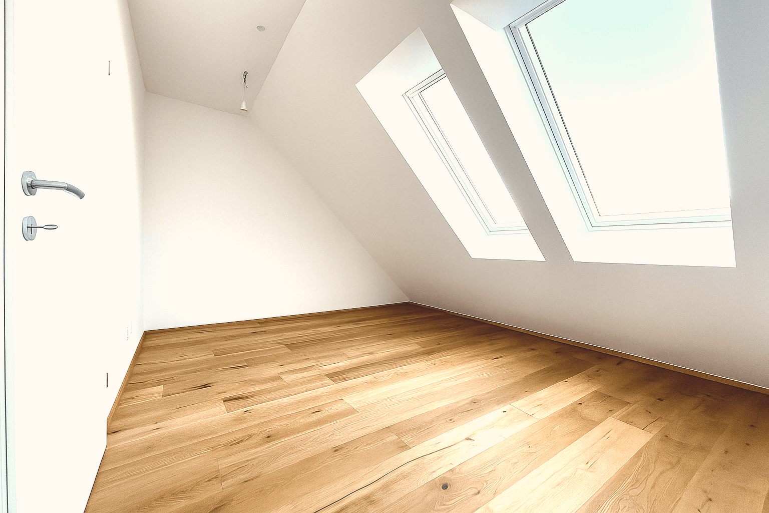 Helles Schlafzimmer im Dachgeschoss mit Holzboden und einem Fenster, das viel Licht spendet.