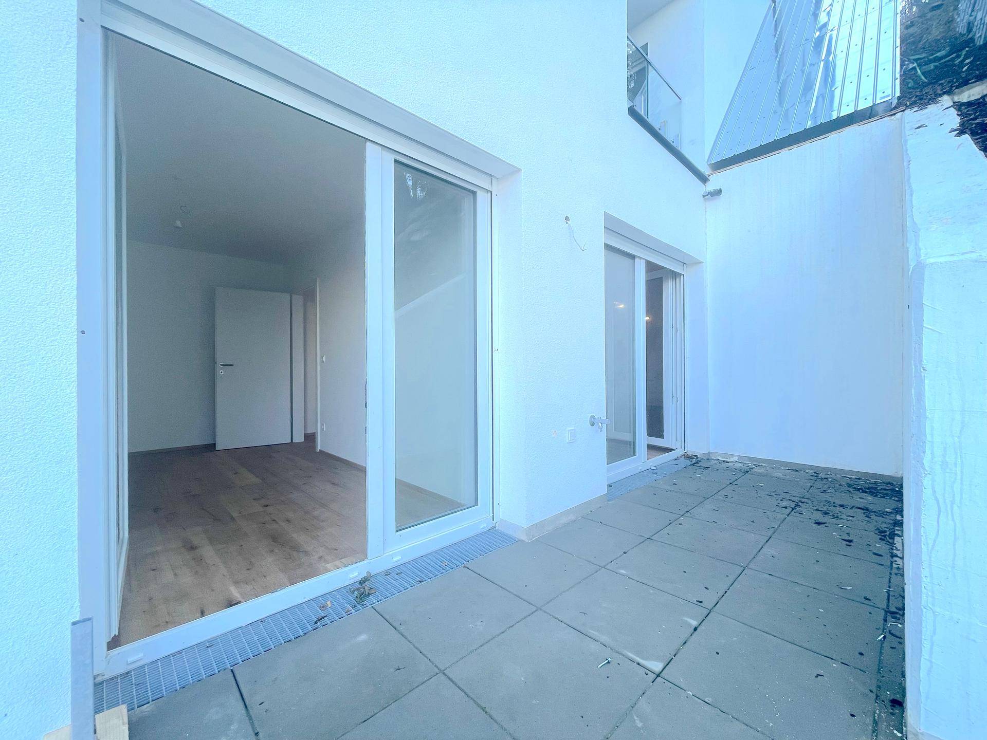 Private Terrasse mit Fliesenboden und direktem Zugang zum Innenbereich, ideal für Entspannung im Freien.