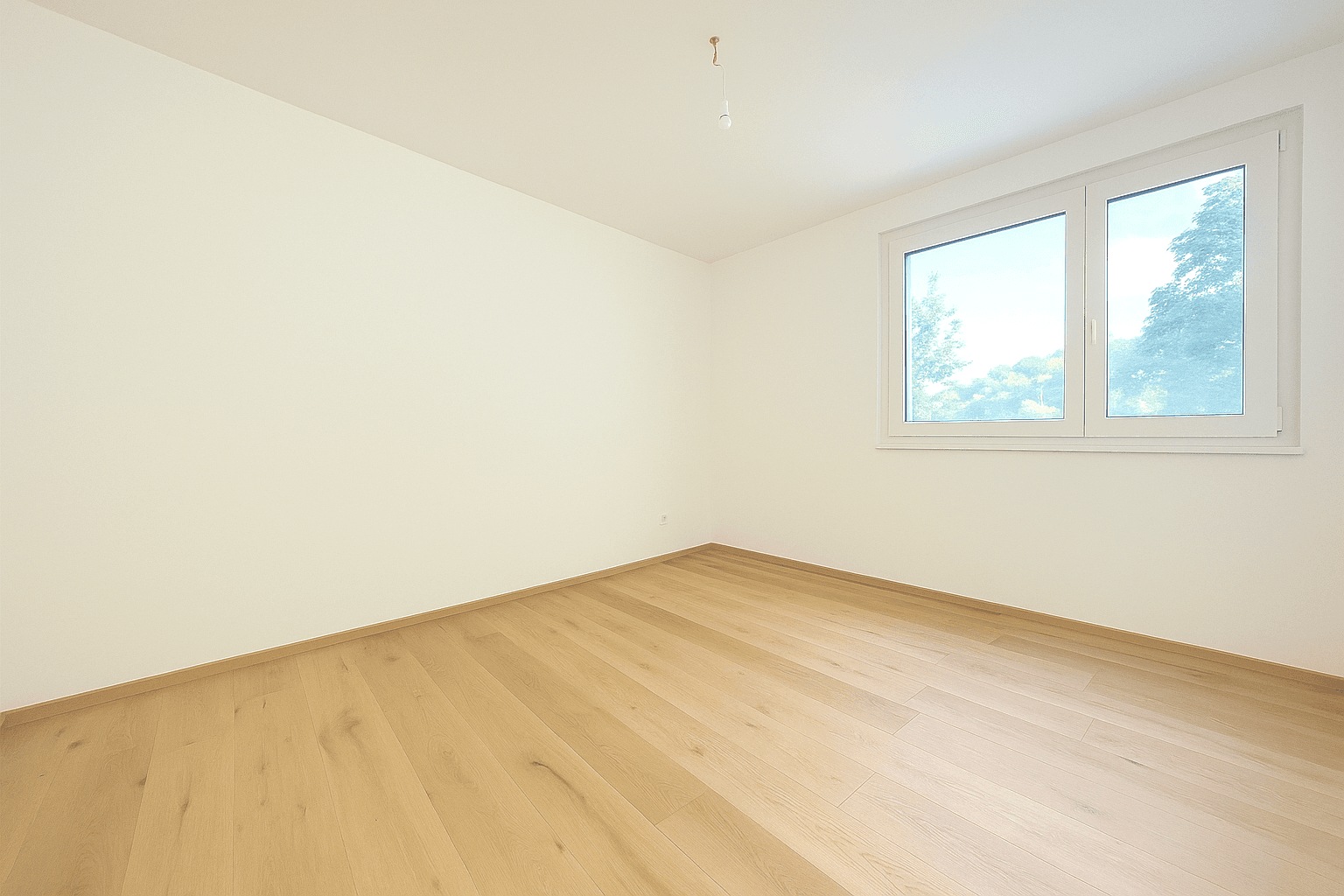 Geräumiges Schlafzimmer mit Holzboden und einem Fenster, das den Blick nach draußen freigibt.