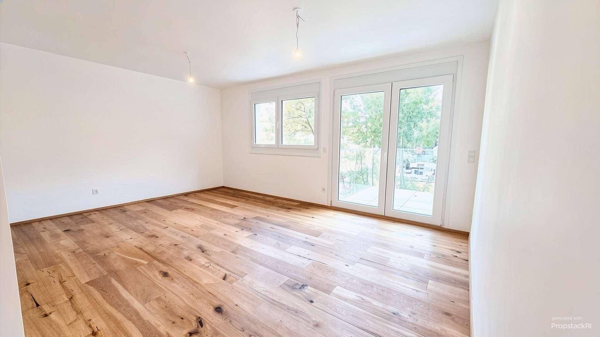 Geräumiges Zimmer mit viel Tageslicht, Holzboden und direktem Zugang zum Außenbereich.