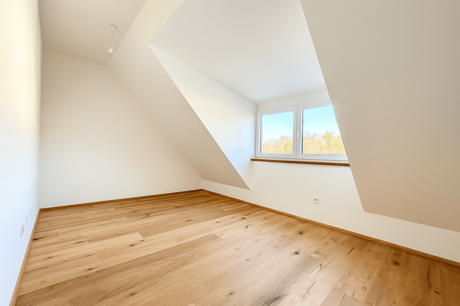 Heller, leerer Wohnraum mit Holzboden und großen Fenstern, die viel Tageslicht hereinlassen.