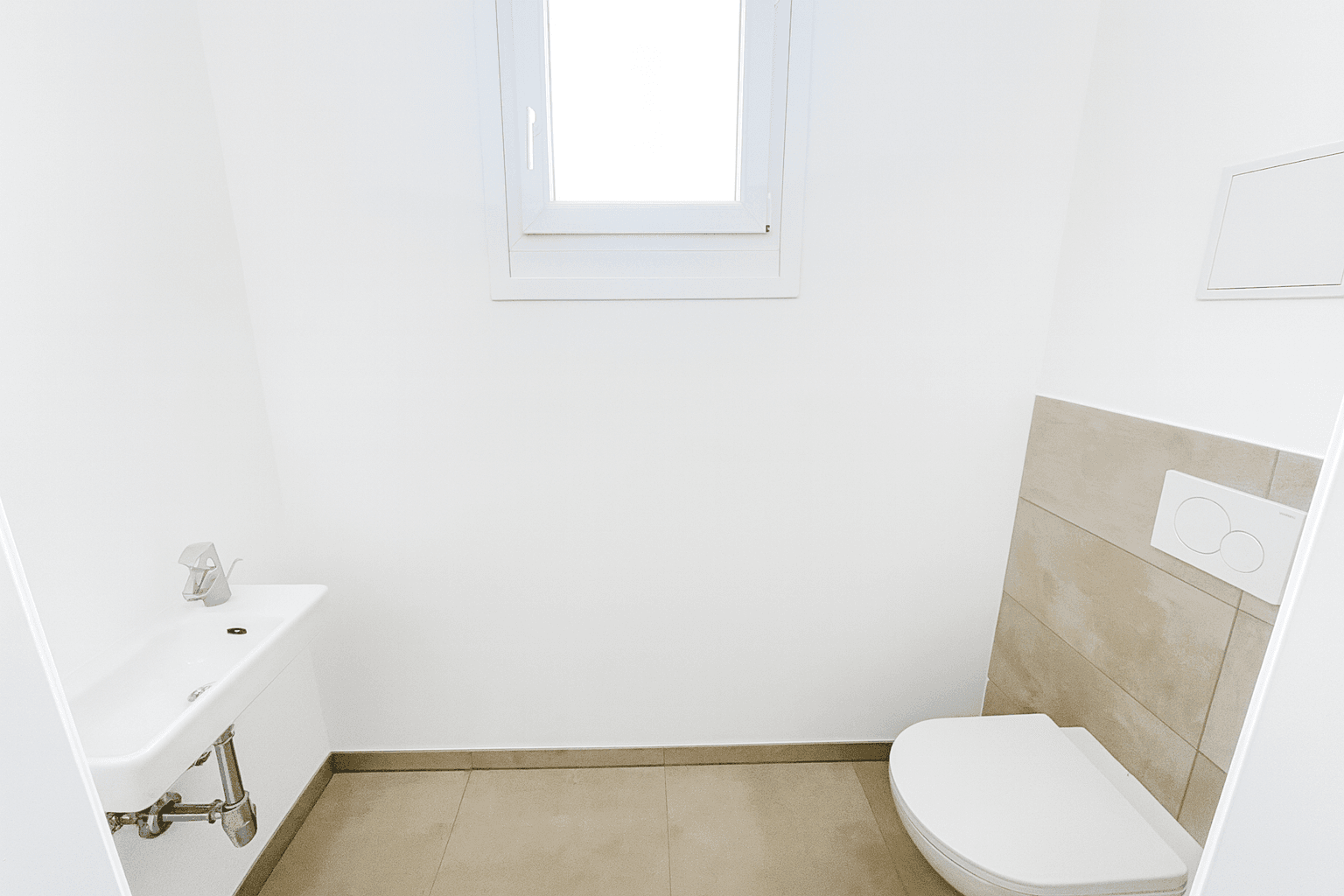 Modernes Badezimmer mit Badewanne, Waschbecken und Wand-WC, ausgestattet mit hellen Fliesen.